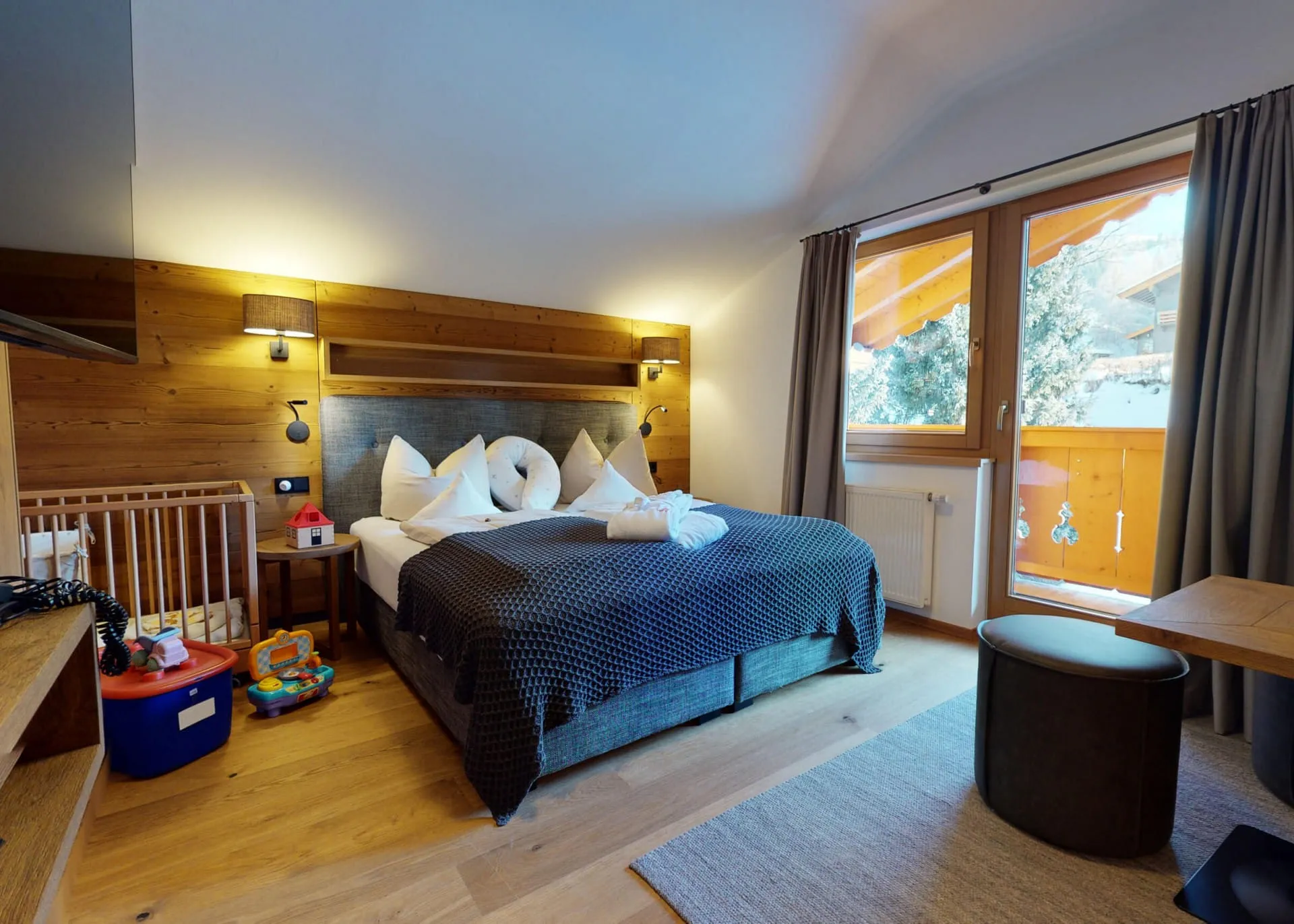 Doppelzimmer mit Babybett und Spielzeugkiste für Kinder