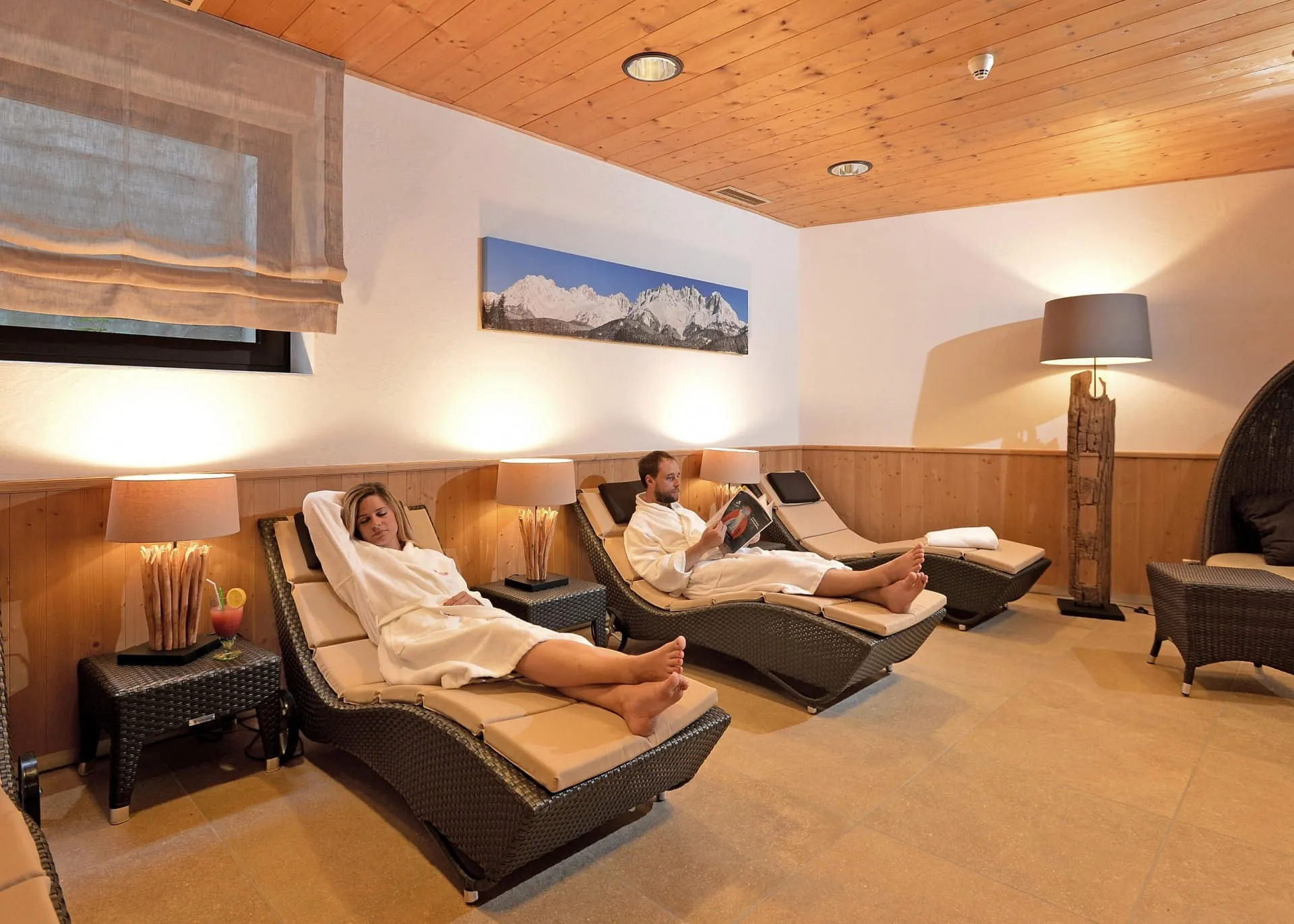 Paar entspannt auf Liegestühlen im Wellness-Ruheraum