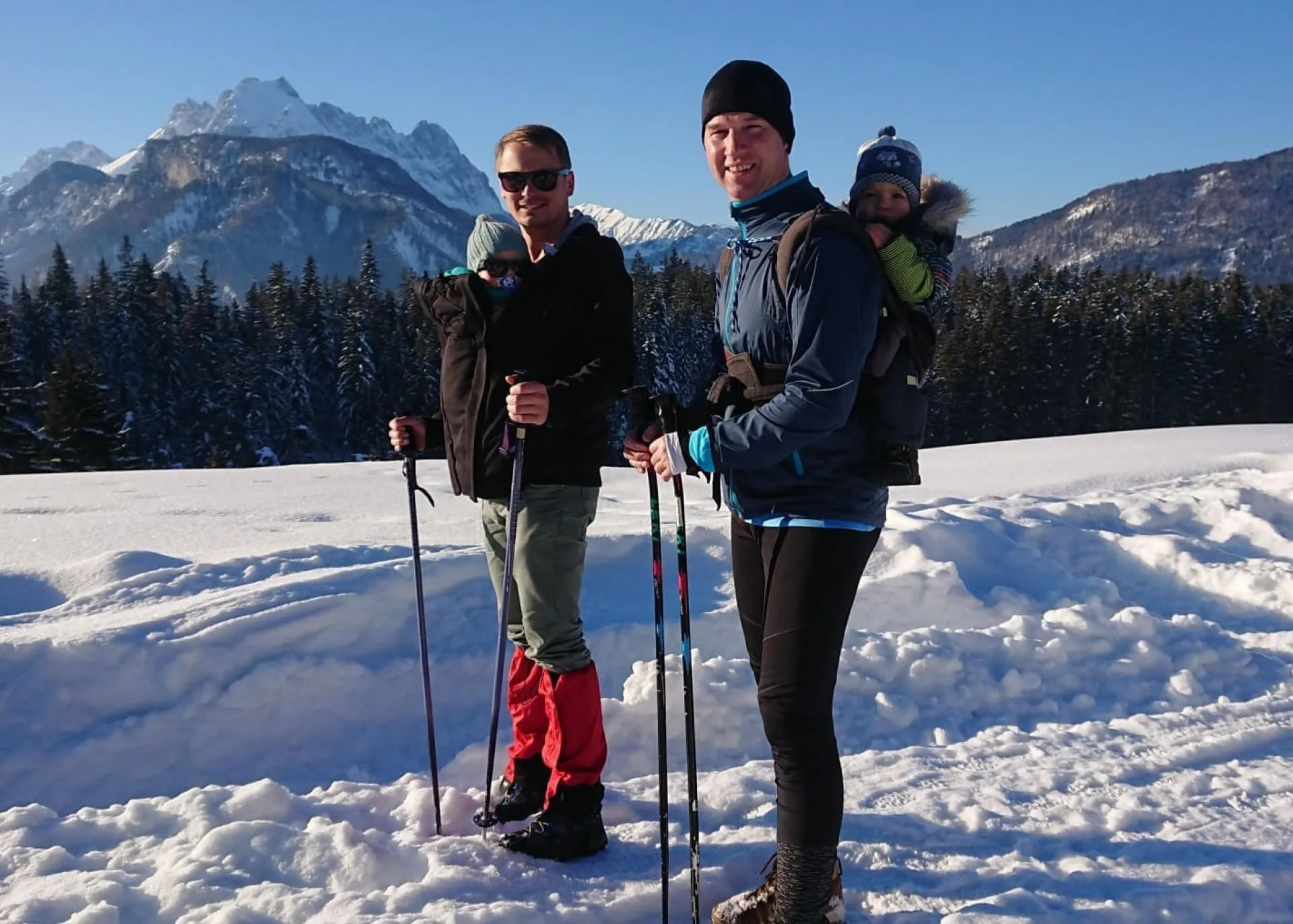 Väter mit Babys in Tragen beim Winterwandern in den Kitzbüheler Alpen